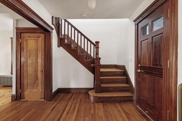 stairway with wood-type flooring and radiator