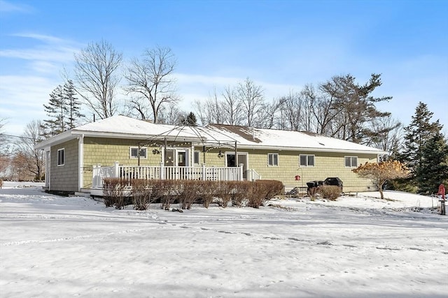 snow covered rear of property with a wooden deck