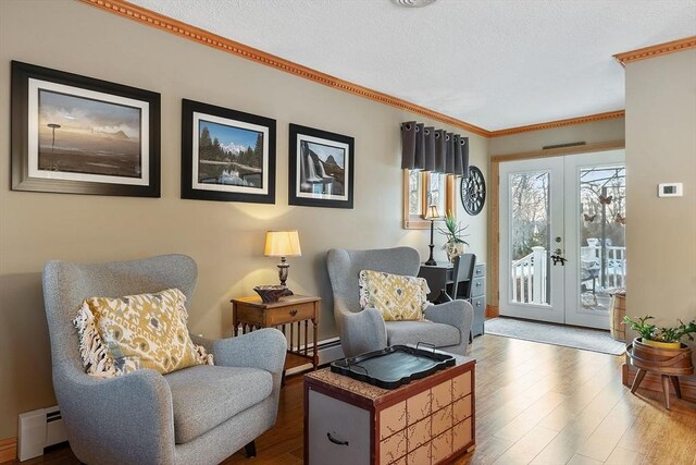 sitting room with hardwood / wood-style flooring, a baseboard radiator, ornamental molding, and french doors