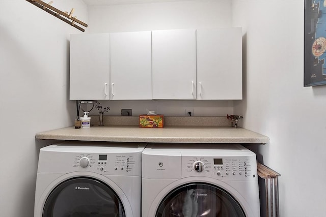 washroom with separate washer and dryer and cabinets