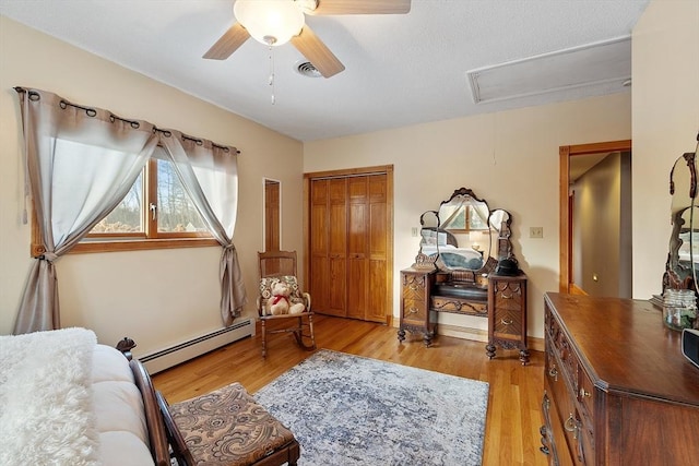 sitting room featuring ceiling fan, baseboard heating, and light hardwood / wood-style flooring