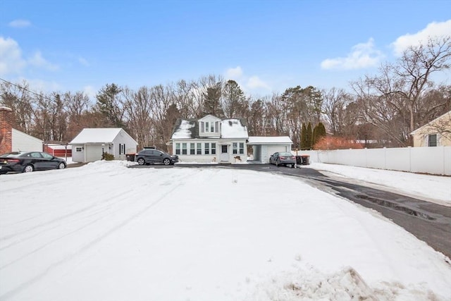 snowy yard featuring fence and an attached garage