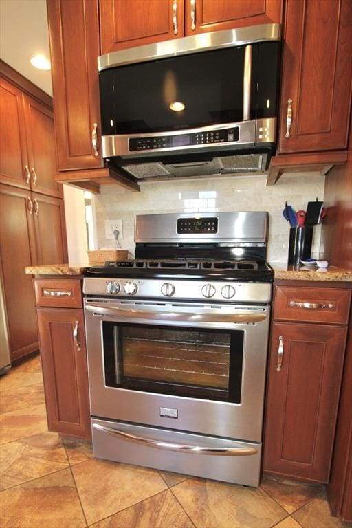25 Rollinson Rd, Worcester, MA 01606 - kitchen featuring appliances with stainless steel finishes, brown cabinets, light stone countertops, and backsplash