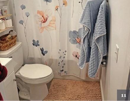 bathroom with toilet, shower / bath combo, and vanity