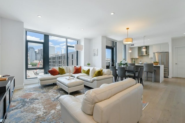 living room with light wood-style flooring, a view of city, visible vents, and recessed lighting