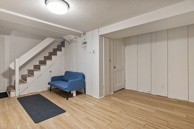 358 Lexington St Unit 358, Watertown, MA 02472 - finished basement with light wood-type flooring, stairs, and a textured ceiling