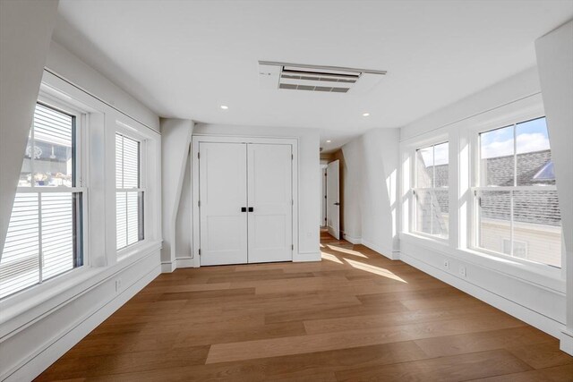 foyer entrance with visible vents, baseboards, wood finished floors, and recessed lighting