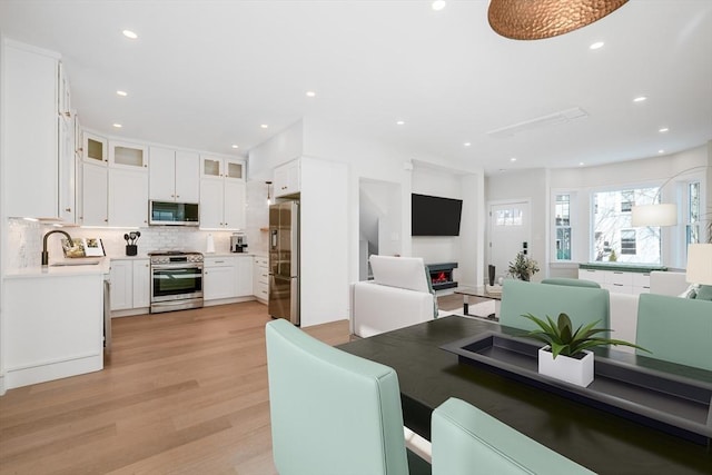 dining area with light wood-type flooring and recessed lighting