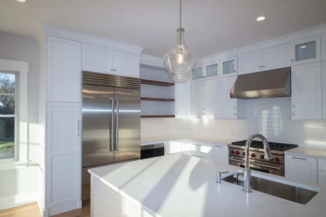 533 Woods Hole Rd Unit B102, Falmouth, MA 02543 - kitchen with white cabinetry, premium appliances, decorative backsplash, hanging light fixtures, and light stone countertops