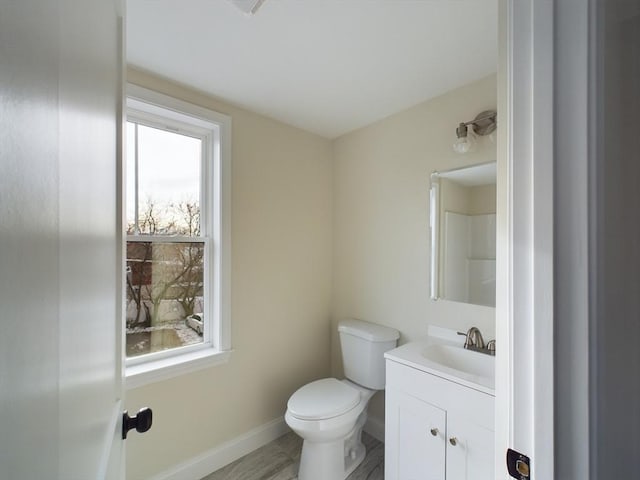 bathroom featuring toilet, vanity, and hardwood / wood-style flooring