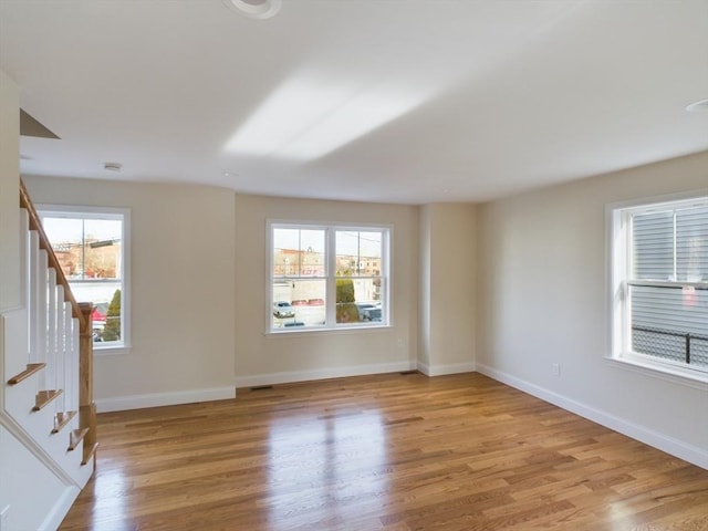 empty room with a wealth of natural light and light wood-type flooring