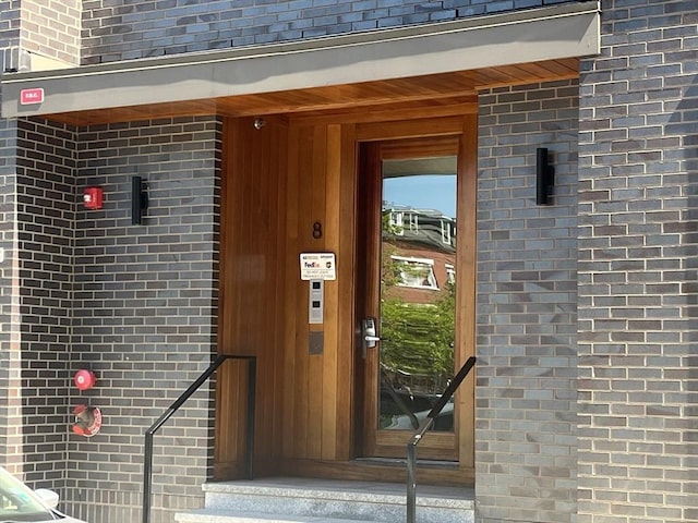 view of exterior entry with brick siding