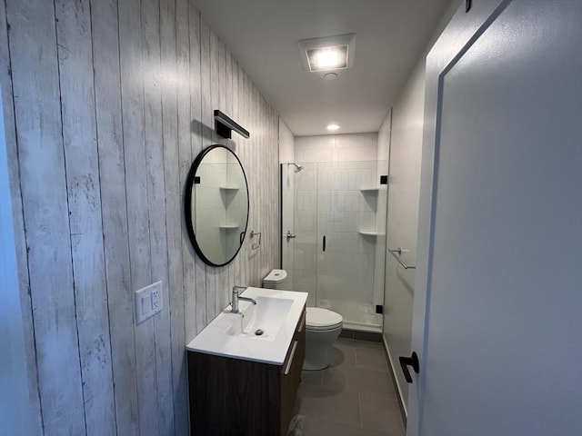 full bath featuring toilet, a stall shower, tile patterned floors, vanity, and wooden walls