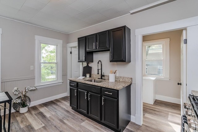 33-35 Claremont St, Springfield, MA 01108 - kitchen featuring a sink, stainless steel gas stove, dark cabinets, light wood finished floors, and crown molding