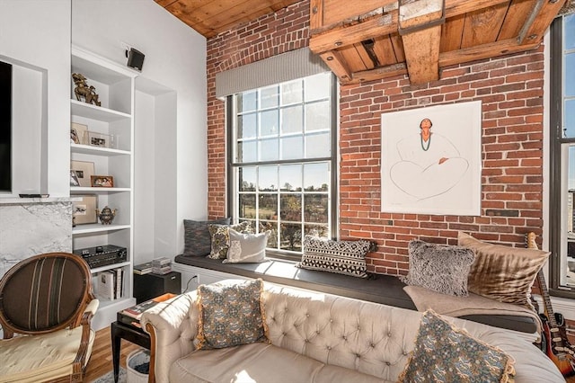 living room featuring wood ceiling, beamed ceiling, brick wall, and wood-type flooring