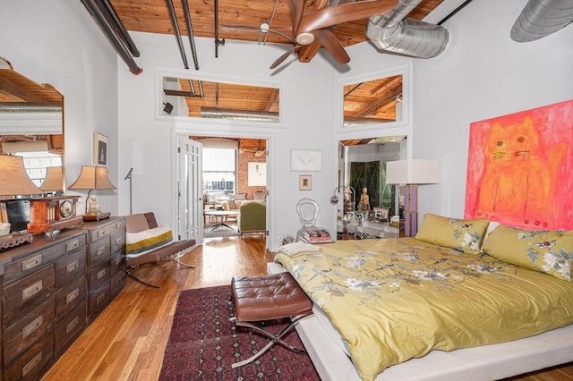 bedroom featuring beam ceiling, light hardwood / wood-style flooring, ceiling fan, and wooden ceiling