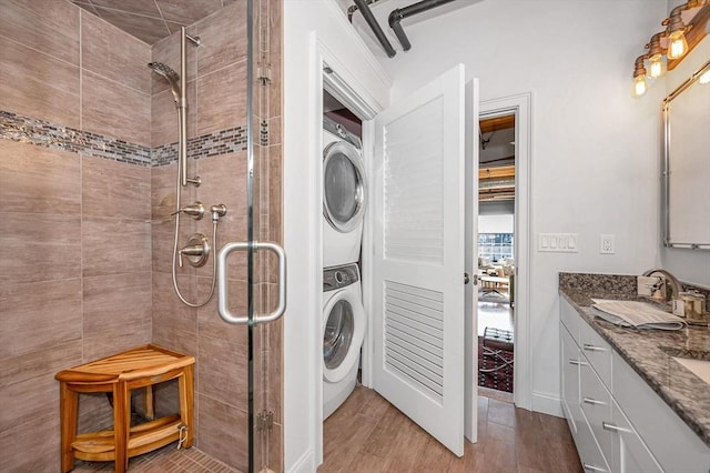 laundry room featuring light hardwood / wood-style floors, stacked washer / dryer, and sink