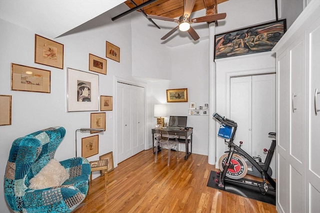 sitting room featuring beamed ceiling, ceiling fan, light hardwood / wood-style floors, and wooden ceiling