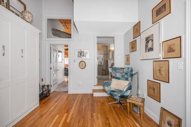 sitting room with vaulted ceiling and light hardwood / wood-style flooring