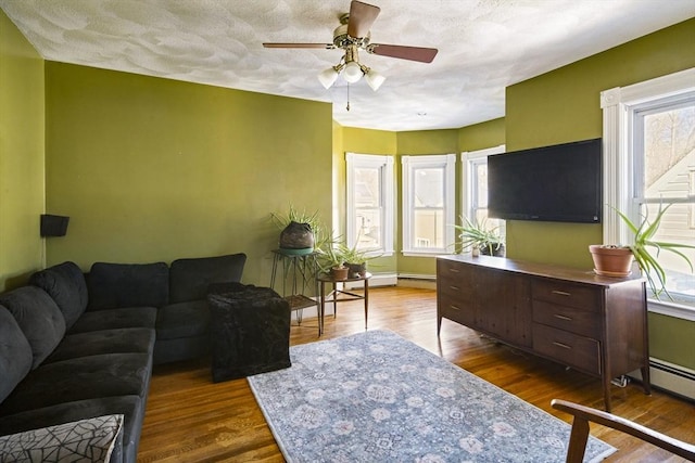 living room with hardwood / wood-style flooring, a textured ceiling, and ceiling fan