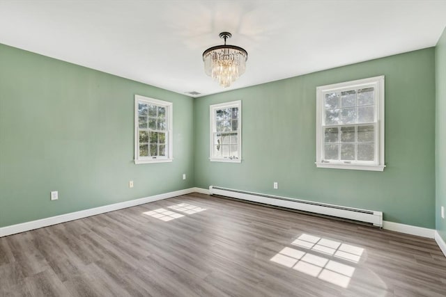 89 Brush Hill Rd, Sherborn, MA 01770 - spare room with an inviting chandelier, baseboards, wood finished floors, a baseboard radiator, and visible vents