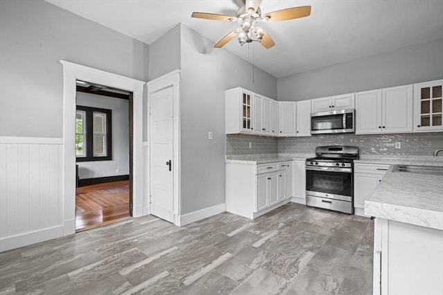 50 Switzer Ave, Springfield, MA 01109 - kitchen featuring appliances with stainless steel finishes, light countertops, ceiling fan, tasteful backsplash, and glass insert cabinets