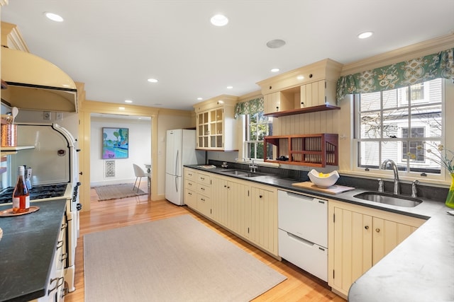 kitchen with white appliances, light hardwood / wood-style flooring, sink, and cream cabinets