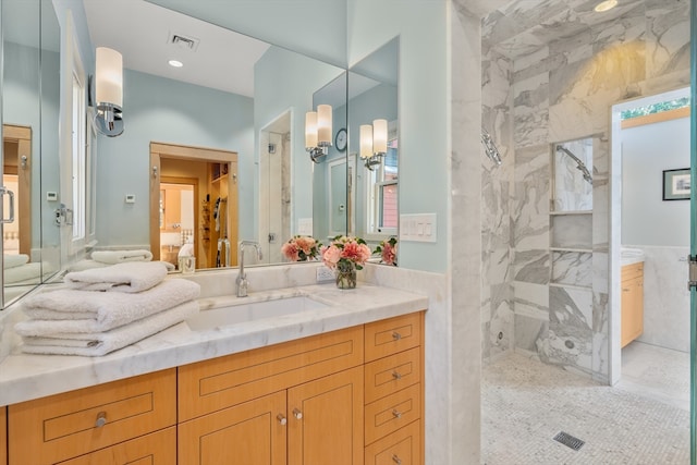 bathroom with vanity, tile walls, and a tile shower