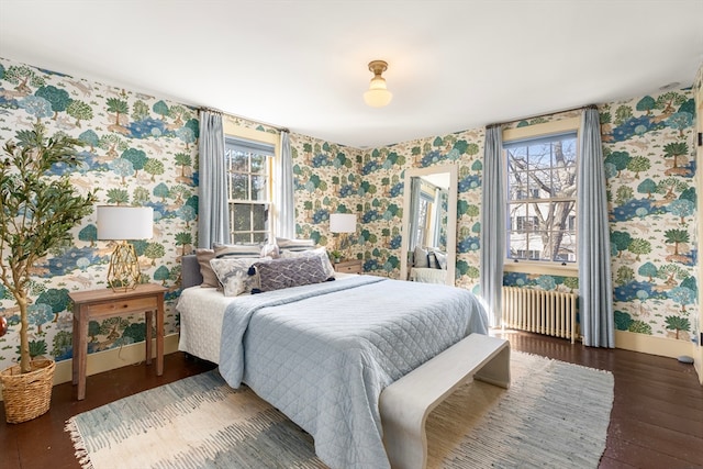 bedroom with radiator, dark hardwood / wood-style floors, and multiple windows