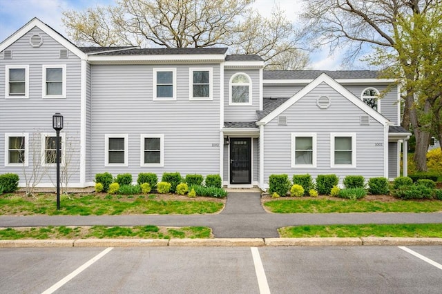 view of front of property featuring a shingled roof and uncovered parking