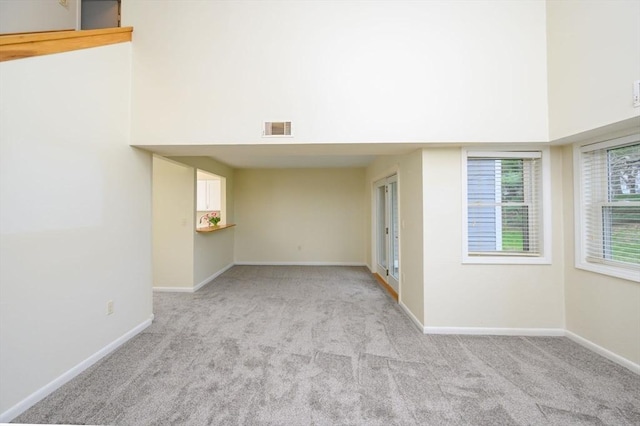 spare room featuring visible vents, baseboards, and light colored carpet