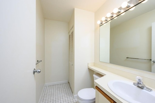 bathroom with vanity, baseboards, and toilet