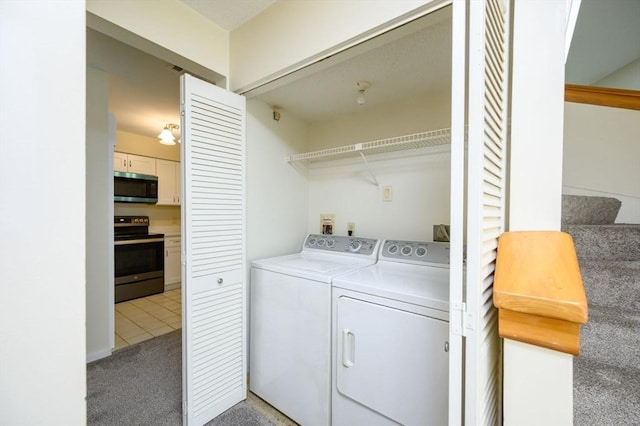 washroom featuring laundry area, light tile patterned floors, light carpet, and washing machine and clothes dryer