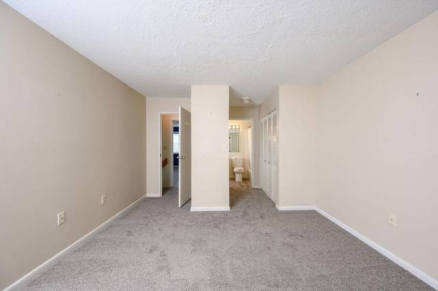 unfurnished bedroom featuring a textured ceiling, baseboards, carpet, and a closet