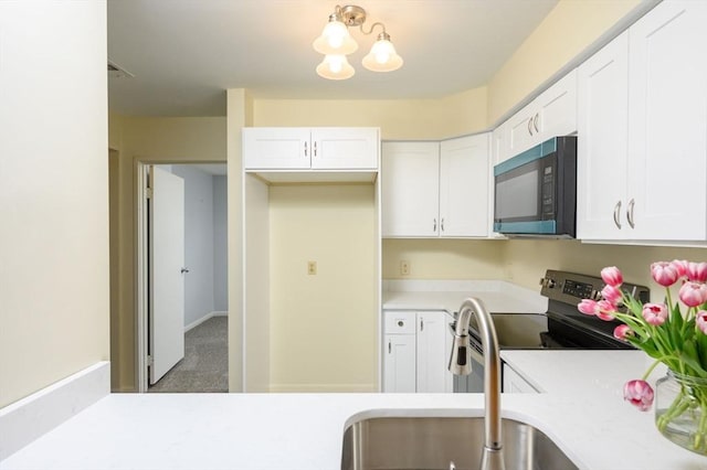 kitchen featuring light countertops, white cabinetry, and a sink