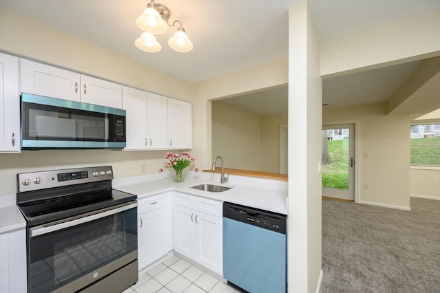 kitchen featuring light countertops, stainless steel appliances, white cabinets, and a sink