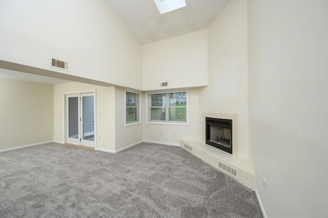 unfurnished living room featuring visible vents, carpet, baseboards, and high vaulted ceiling