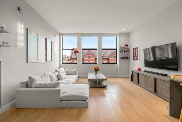 living area featuring light wood-style flooring and baseboards