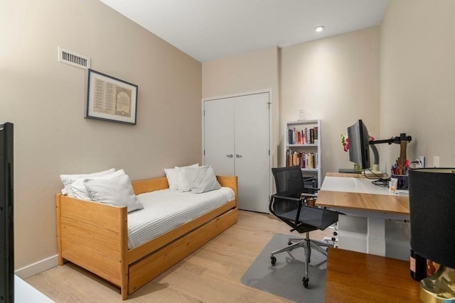 office with light wood-style flooring, visible vents, and baseboards