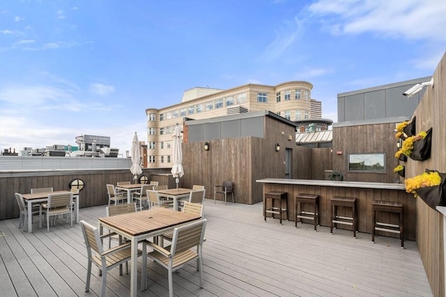 wooden deck with outdoor dry bar, outdoor dining area, and a city view