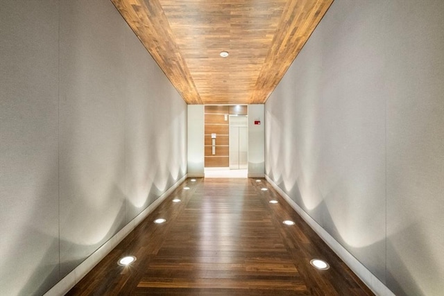 hall featuring wood finished floors, wood ceiling, and baseboards