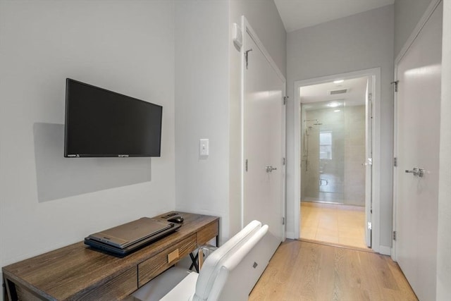 corridor featuring light wood-style floors and visible vents