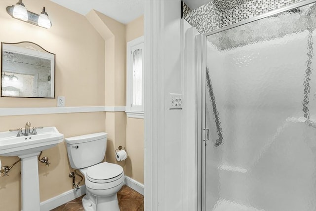 full bathroom featuring a shower stall, toilet, tile patterned flooring, baseboards, and a sink