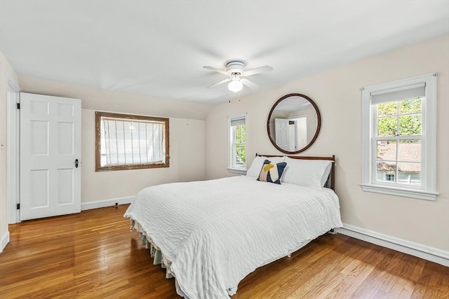 bedroom featuring baseboards, wood finished floors, and a ceiling fan