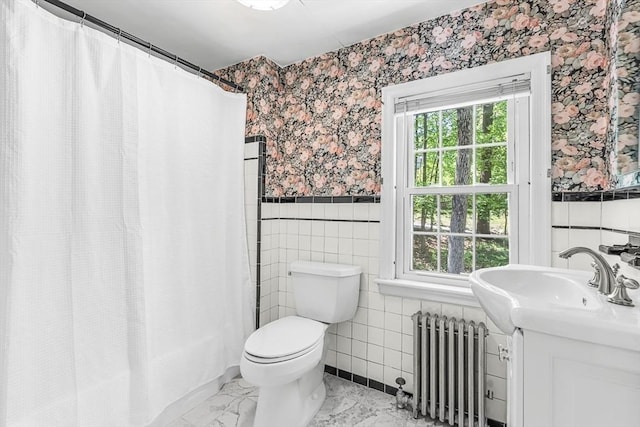 full bath with radiator, wallpapered walls, tile walls, wainscoting, and vanity