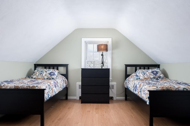 bedroom with vaulted ceiling and light hardwood / wood-style flooring