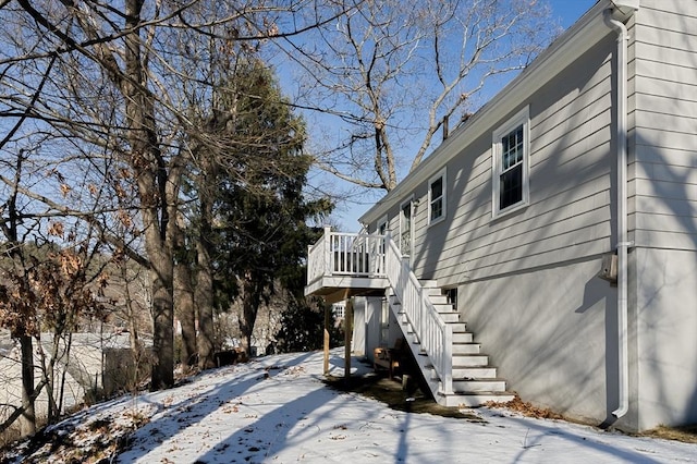 view of snowy exterior with a wooden deck