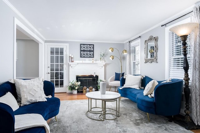 living room featuring crown molding, a brick fireplace, and hardwood / wood-style floors