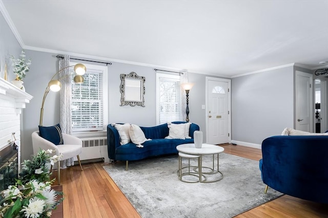 living room with ornamental molding, radiator, hardwood / wood-style floors, and a fireplace