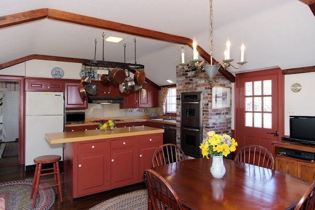 kitchen featuring lofted ceiling, plenty of natural light, and white refrigerator